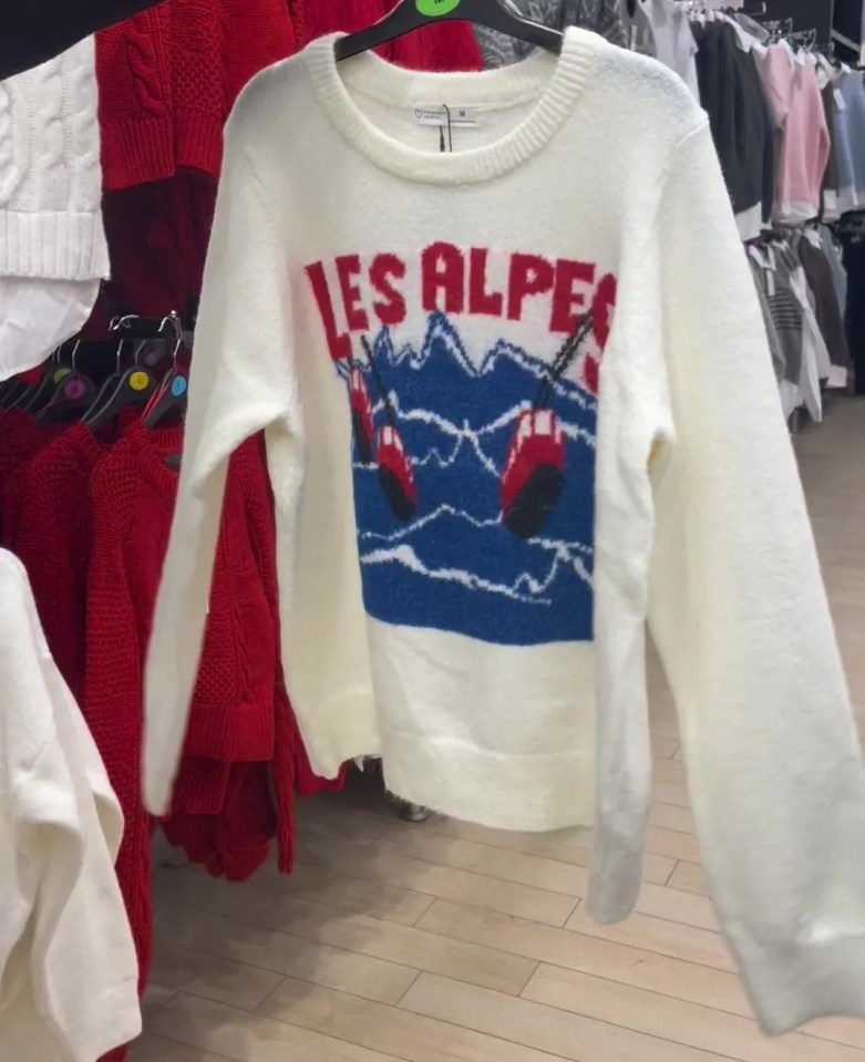 White sweater with "Les Alpes" and ski lift illustration.