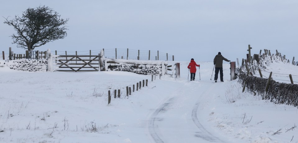 Walkers attempt to make their way through the snow on Wednesday near Wootton, Staffordshire