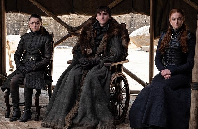 Sansa, Jon Snow (in a wheelchair), and Arya Stark seated together.