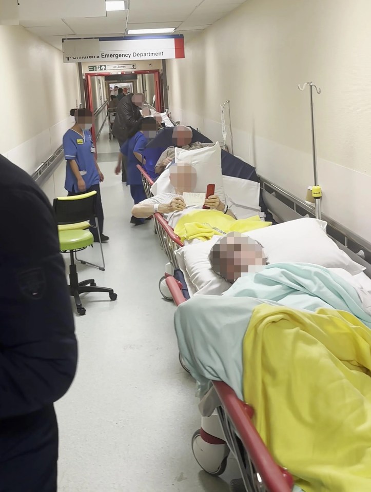 Patients waiting on gurneys in a hospital corridor.