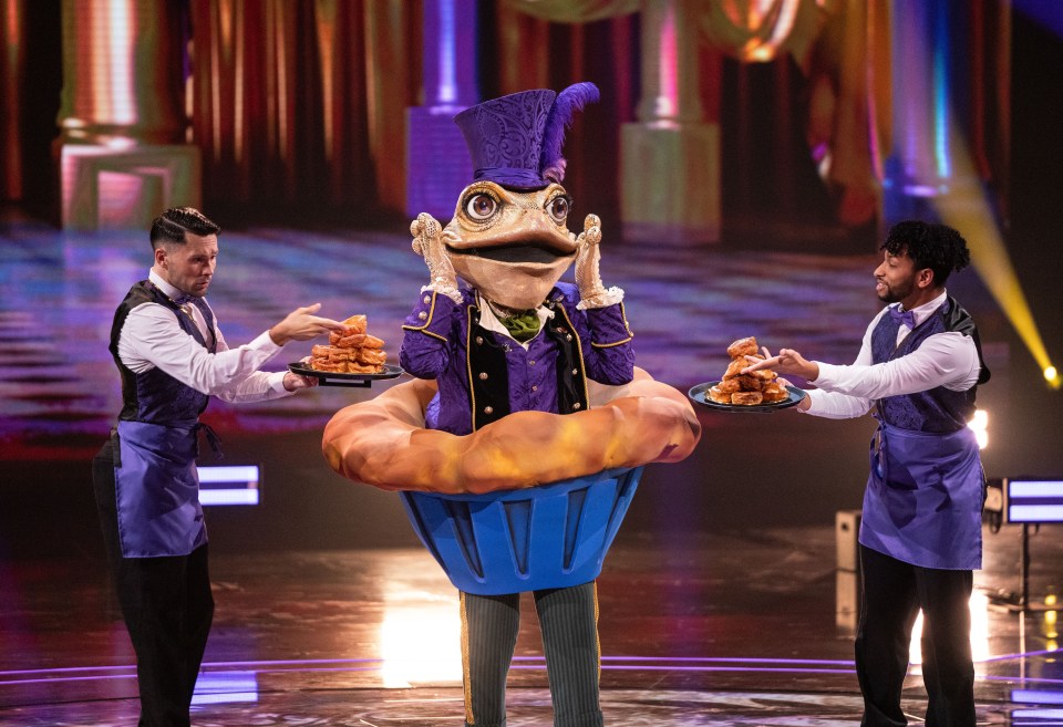 Toad costume on The Masked Singer, being served food by two waiters.