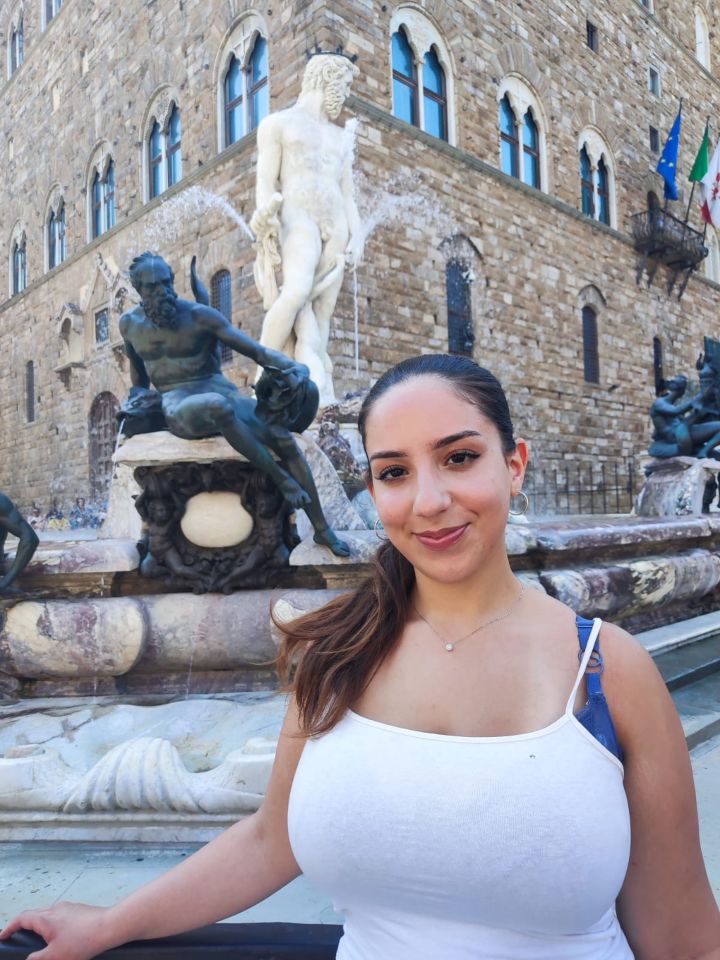 Woman in front of a fountain with statues.