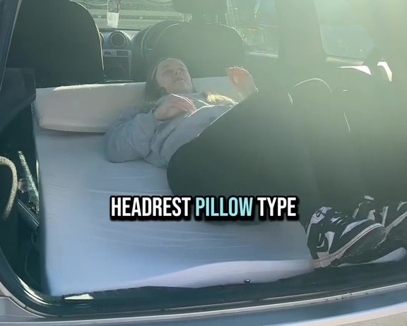 Person sleeping on a mattress in the back of a car.