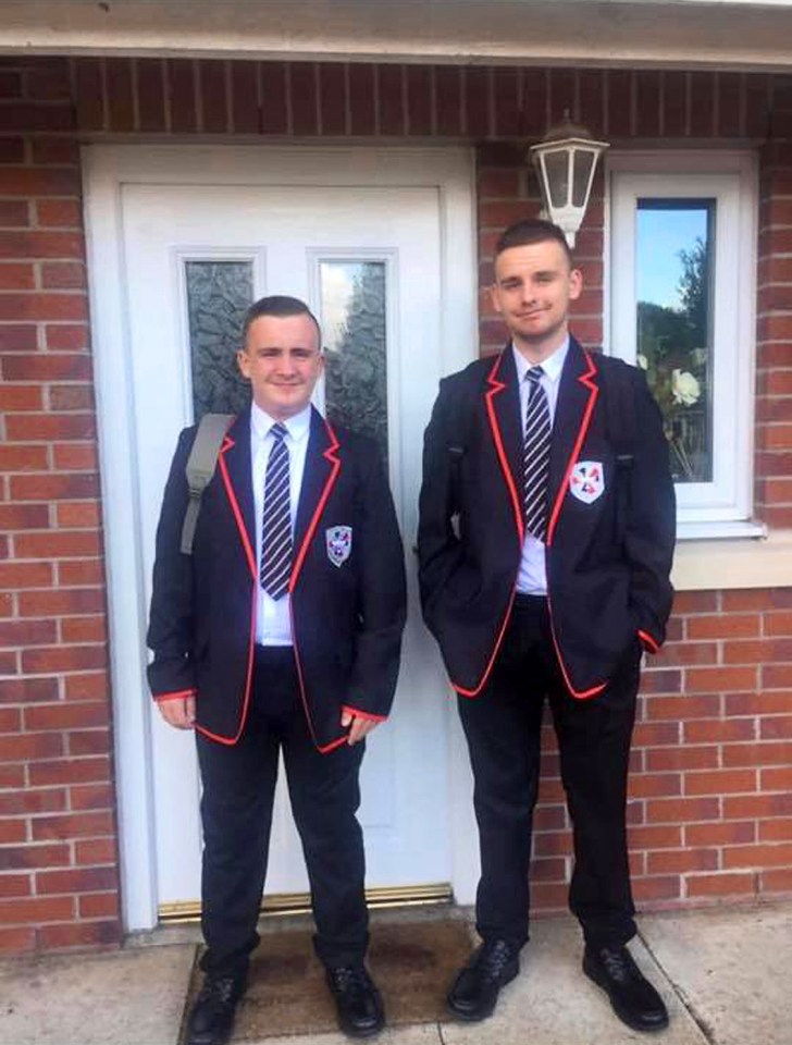 Two boys in school uniforms standing in front of a house.