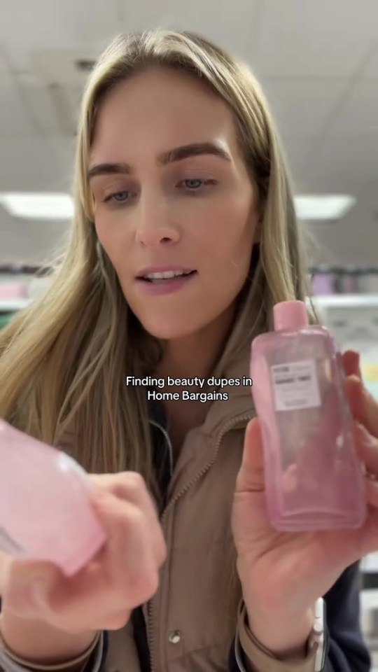 Woman holding two bottles of pink beauty product dupes found at Home Bargains.