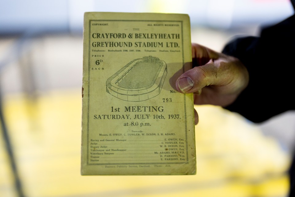 A hand holding a 1937 Crayford & Bexleyheath Greyhound Stadium program.