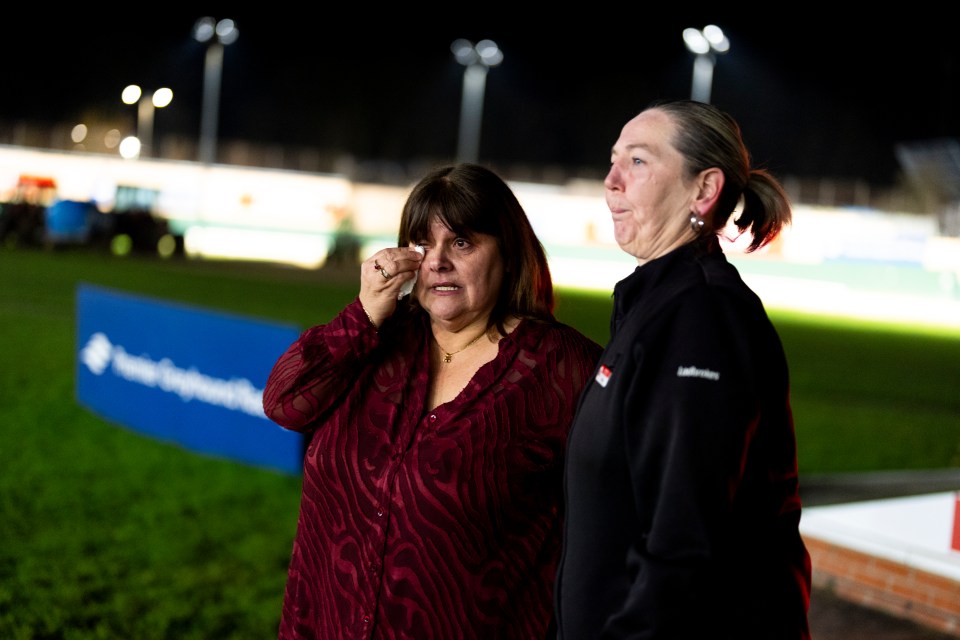 Two women crying at a greyhound racing stadium closure.