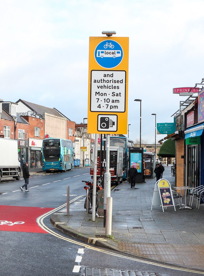 Photo of a street scene with a sign indicating restrictions on vehicle access during certain hours.