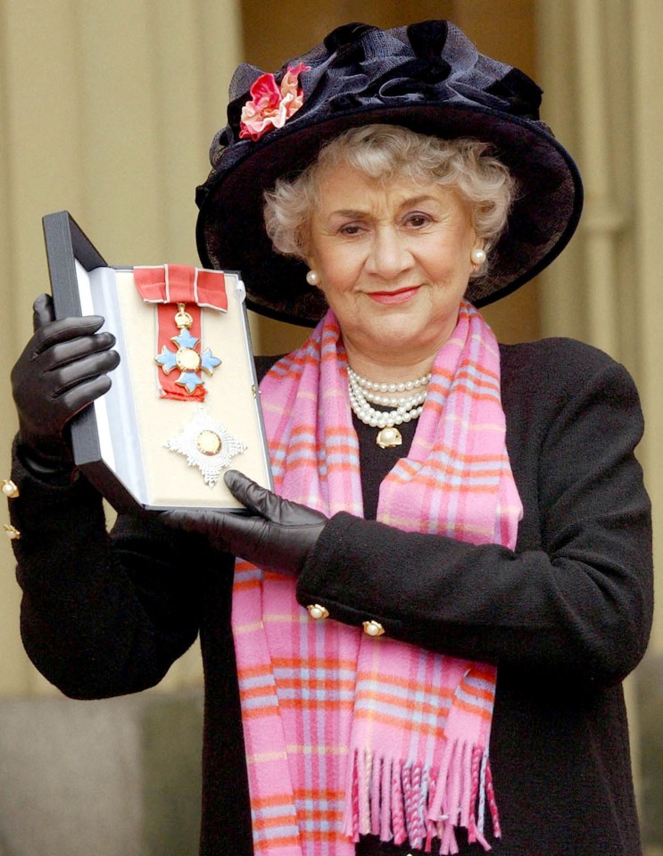 Joan Plowright holding her Damehood award at Buckingham Palace.