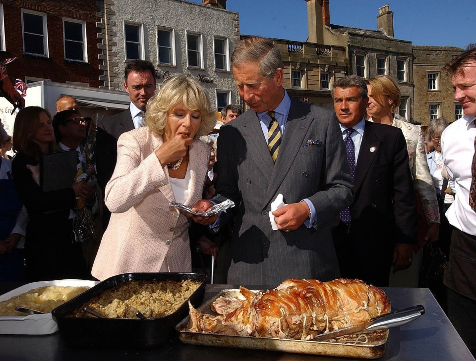 Prince Charles and Camilla, Duchess of Cornwall, sample roast pork at a market.