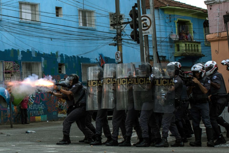 Police officers in riot gear firing weapons at suspected drug users in Sao Paulo, Brazil.