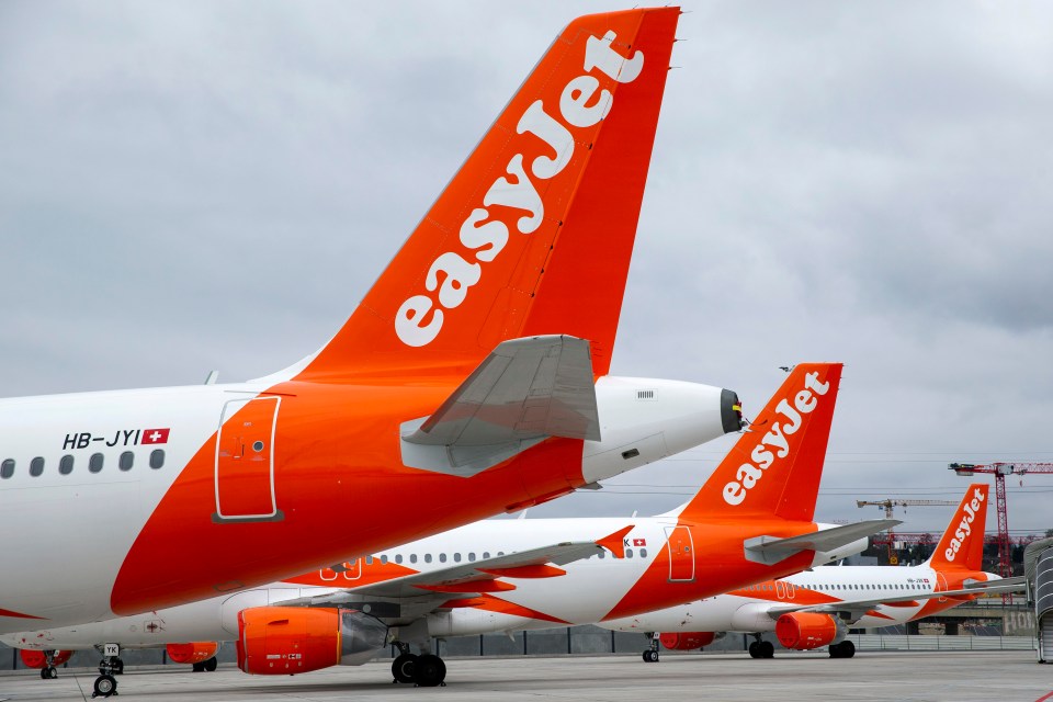 Several easyJet airplanes parked at an airport.