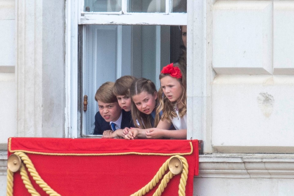 Prince George, Princess Charlotte, Prince Louis, and Mia Tindall watching Trooping the Colour from a window.