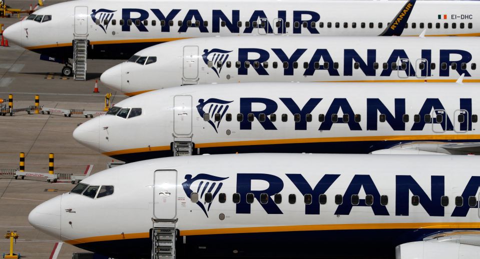 Three Ryanair airplanes parked at an airport.