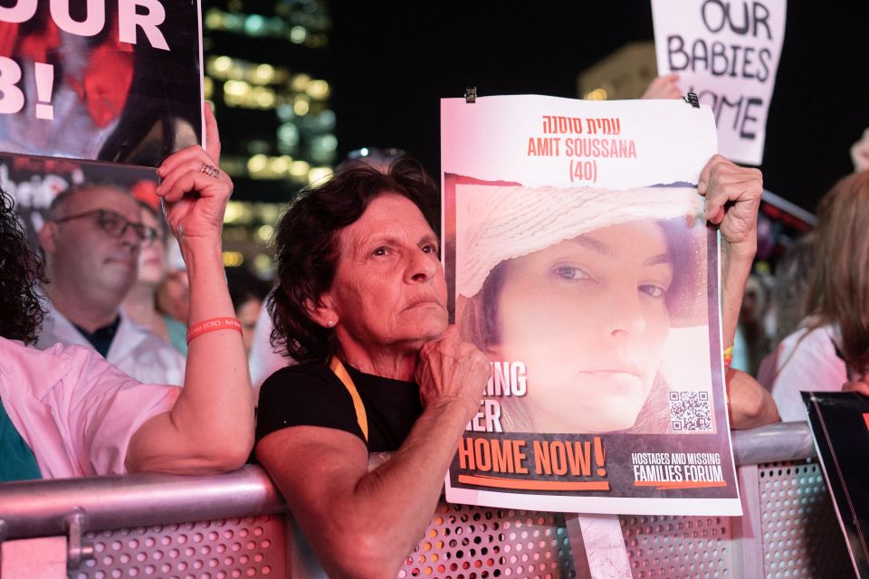 A woman holds a photo of Amit Soussana, a hostage in Gaza, at a protest in Tel Aviv.