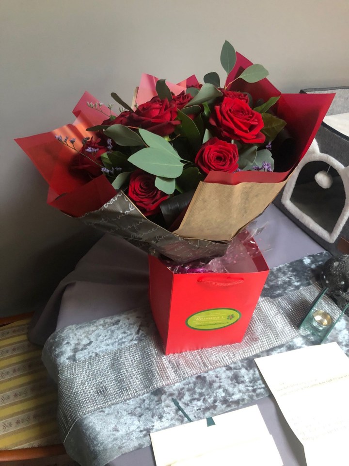 Bouquet of red roses in a red gift bag.