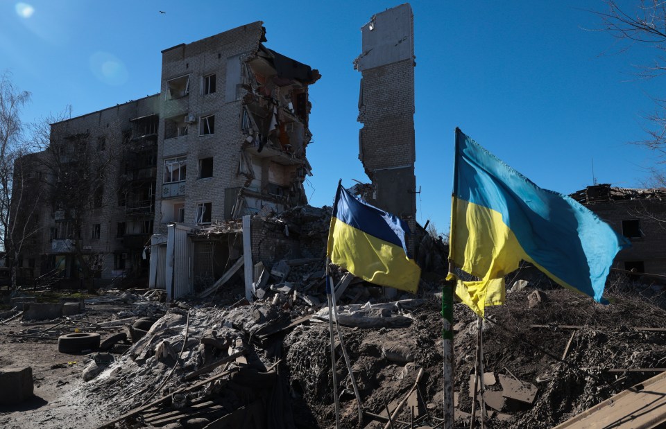 Ukrainian flags in front of damaged buildings in Orikhiv, Ukraine.