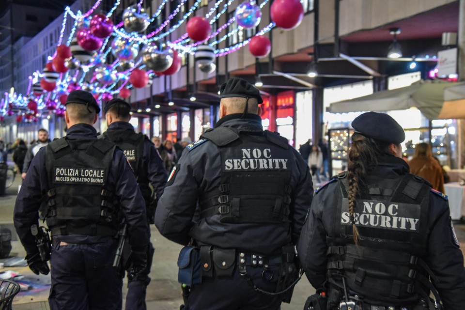 Police officers patrolling a city center during New Year's Eve celebrations.