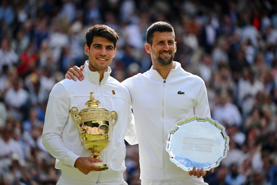 Carlos Alcaraz and Novak Djokovic at the Wimbledon Championships.  Alcaraz holds the winner's trophy.