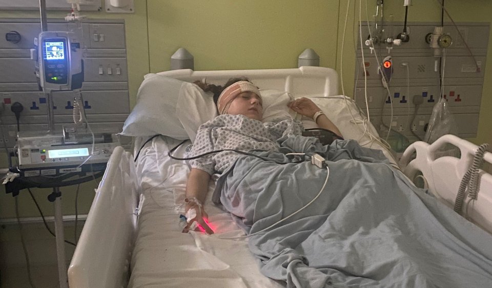 Girl lying in a hospital bed after brain tumour surgery.