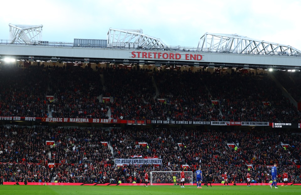 Manchester United fans at Old Trafford holding banners.