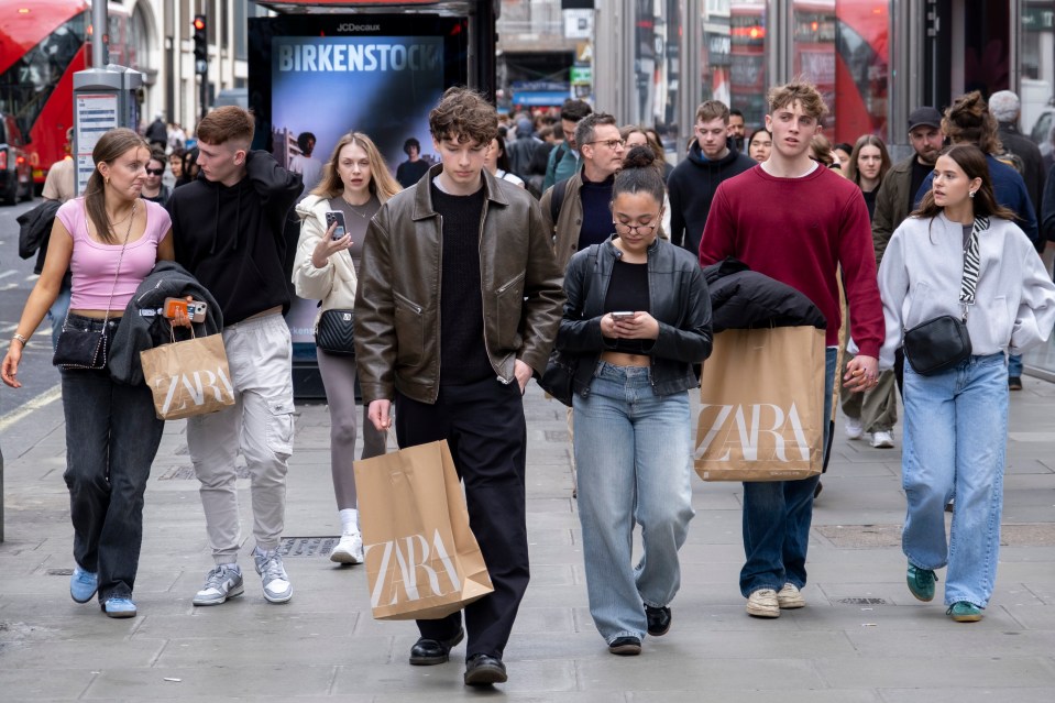 Shoppers with Zara bags walk down Oxford Street in London.