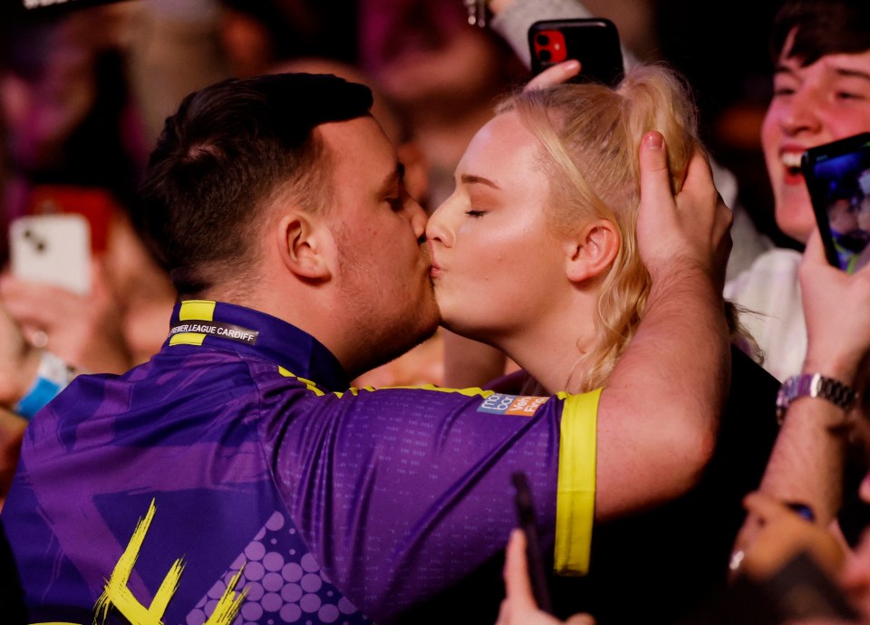 Luke Littler kissing his girlfriend before a darts match.