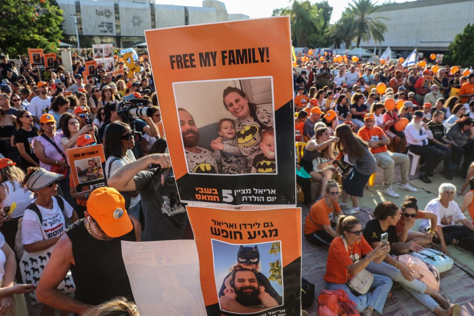 Protestors holding signs demanding the release of a family held hostage.