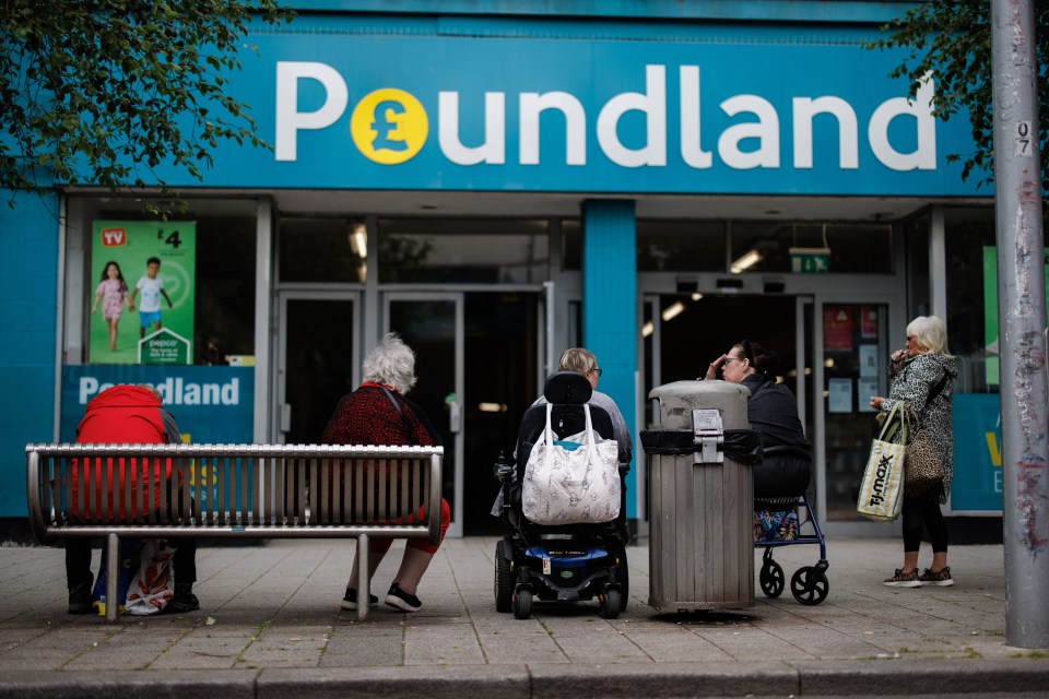 People sitting outside a Poundland store.