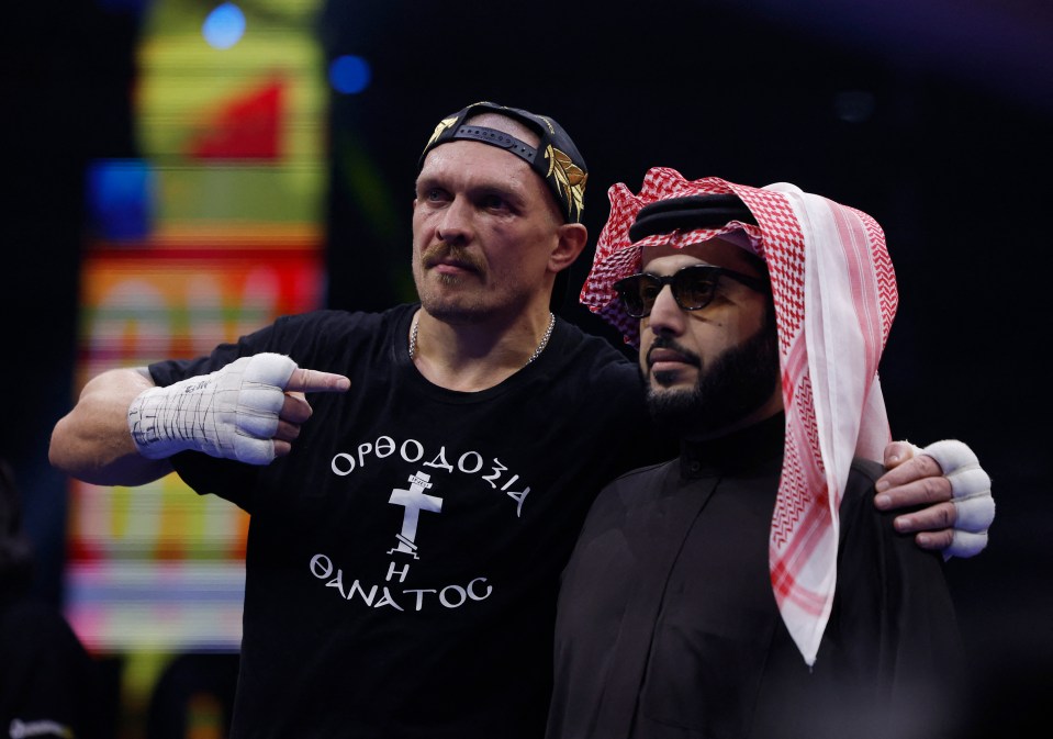 Oleksandr Usyk celebrates with Turki bin Abdulmohsen Alalshikh after a boxing match.