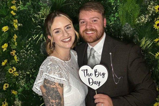 A bride and groom holding a sign that says &quot;The Big Day.&quot;