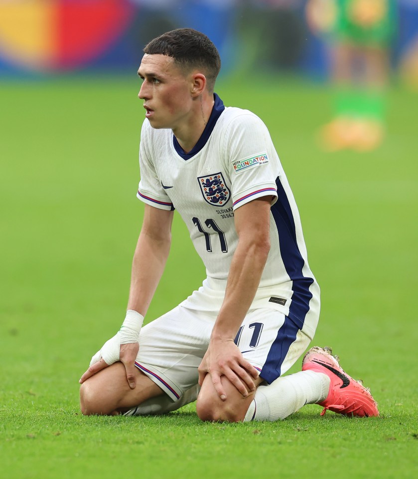 Phil Foden of England kneeling on the field.