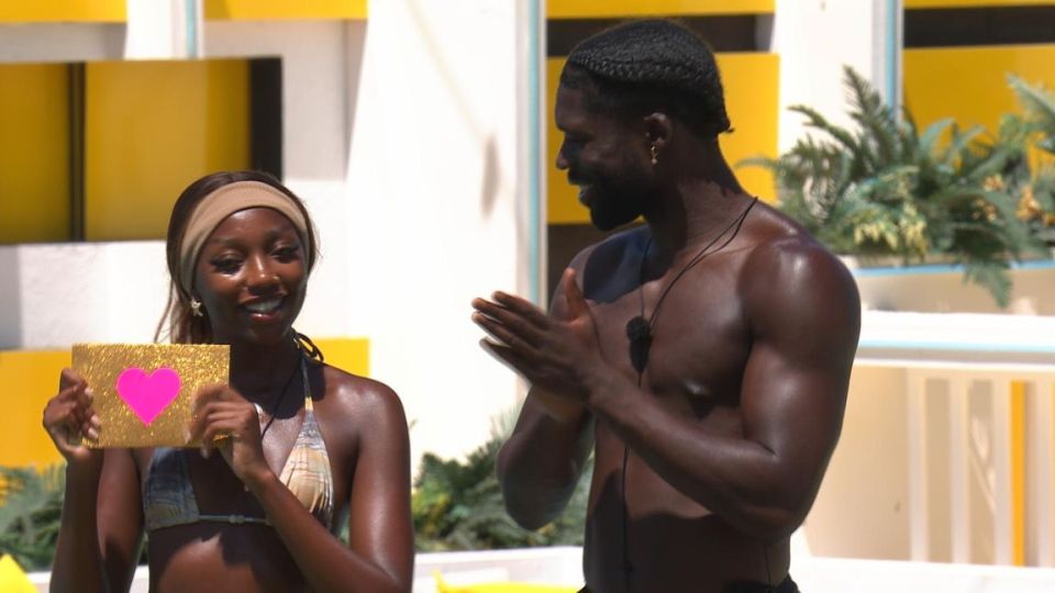 Mimii Ngulube and Josh Sunday Oyinsan from Love Island holding a heart-shaped card.