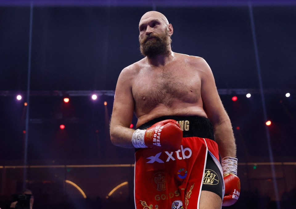 Tyson Fury in boxing ring, wearing red boxing gloves.