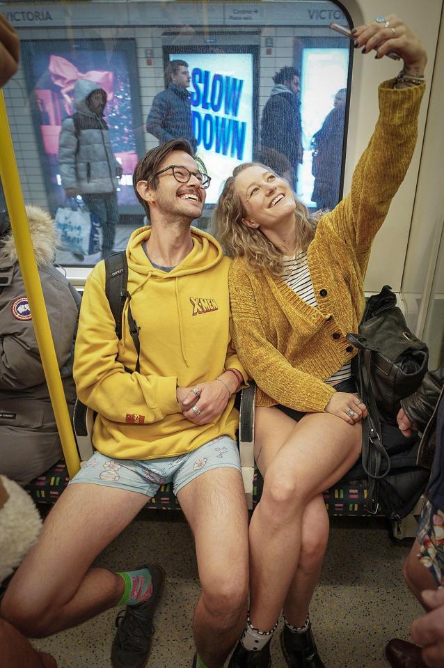 Two people without trousers on the London Underground taking a selfie.