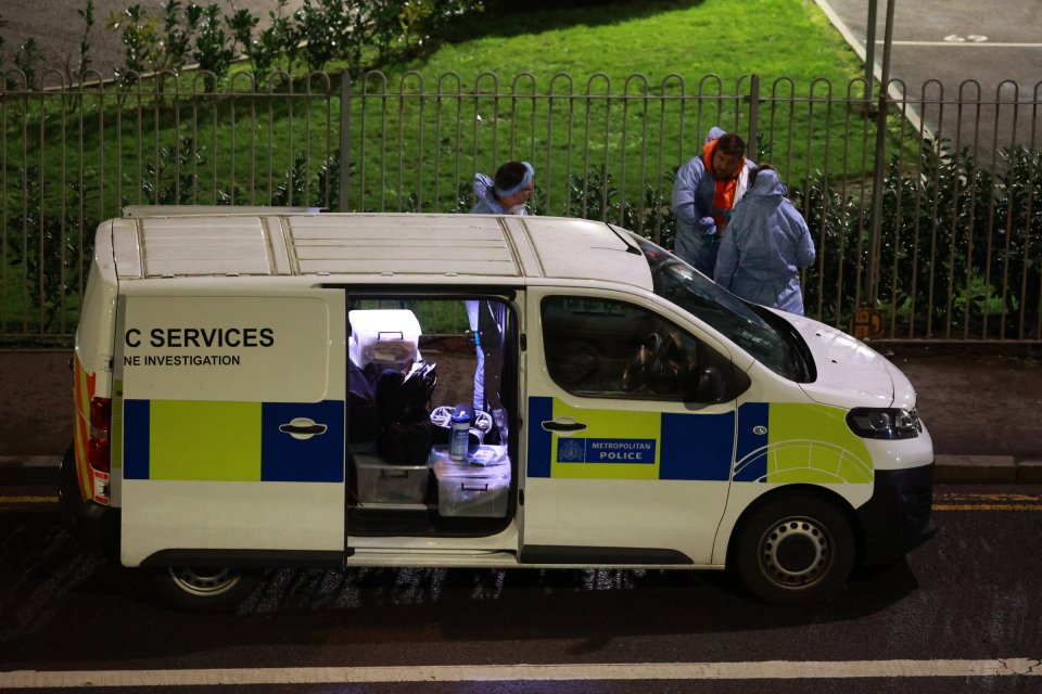 Forensic officers gather evidence as police guard a cordon