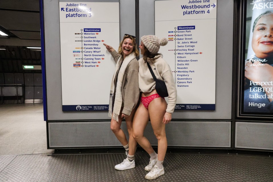 Two women in underwear participate in the No Trousers Tube Ride on the London Underground.