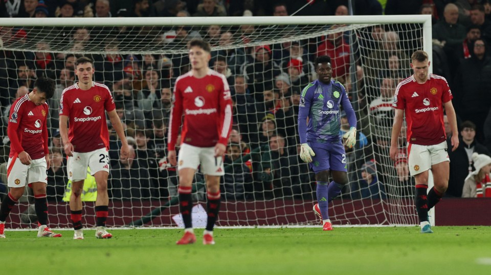 Manchester United players look dejected after a goal.