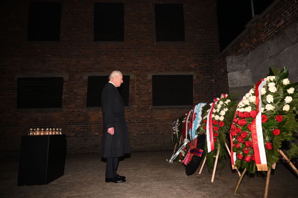 King Charles III at Auschwitz-Birkenau, viewing floral tributes at the Death Wall.