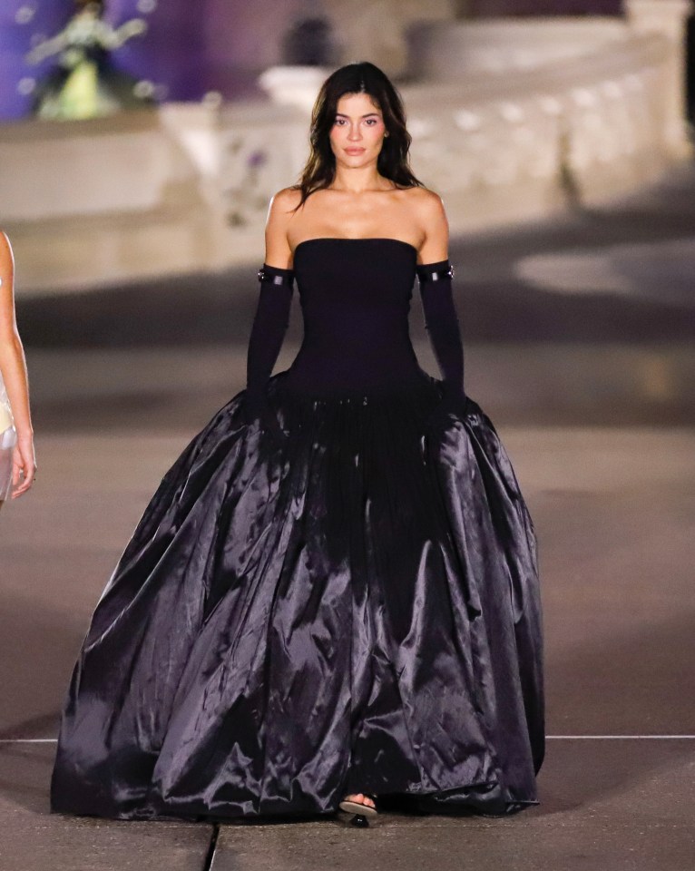 Kylie Jenner modeling a black strapless gown at the Coperni Paris Fashion Week show.