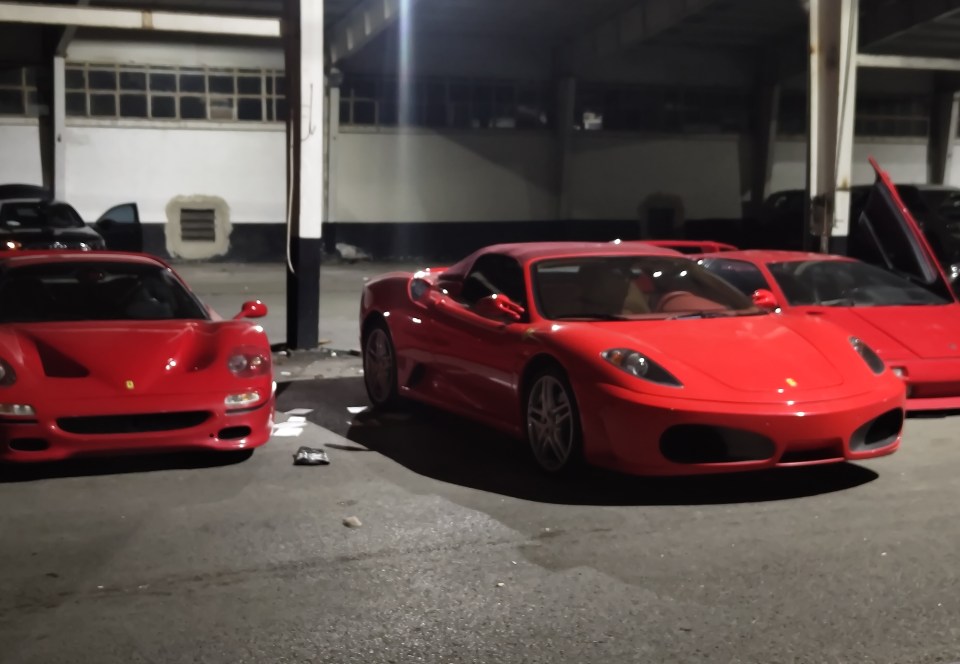 Three red luxury cars parked in a garage.