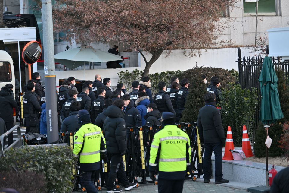 Corruption investigators outside the residence in Seoul on Friday morning