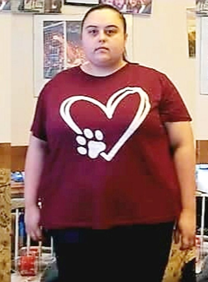 Woman wearing a maroon t-shirt with a paw print inside a heart design.