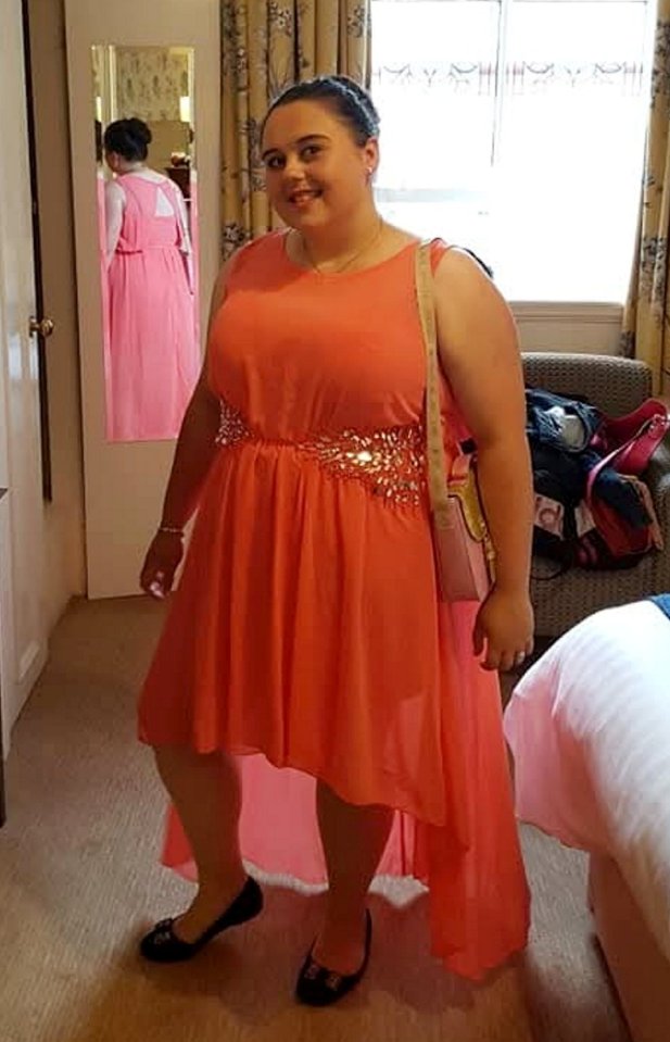 Woman in coral dress after weight loss.