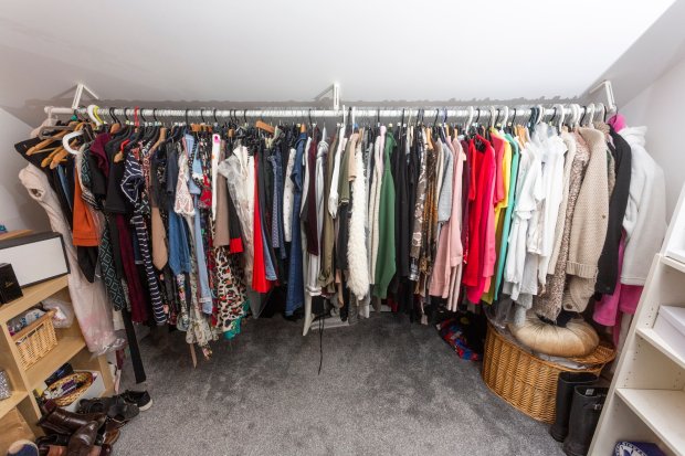 A full wardrobe of clothes hanging on a rack.