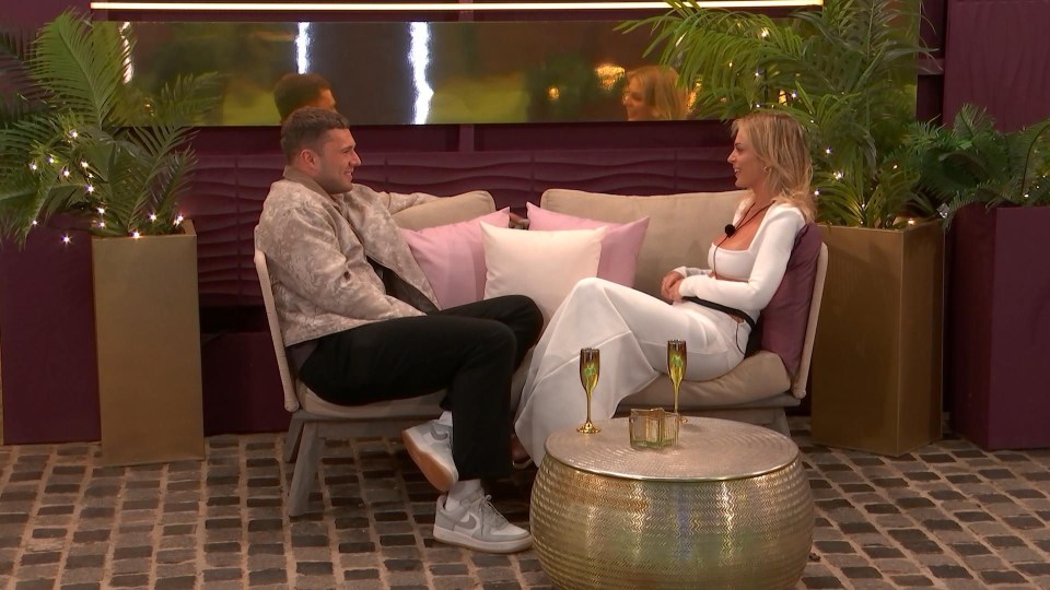 Two Love Island contestants sitting on a couch together.