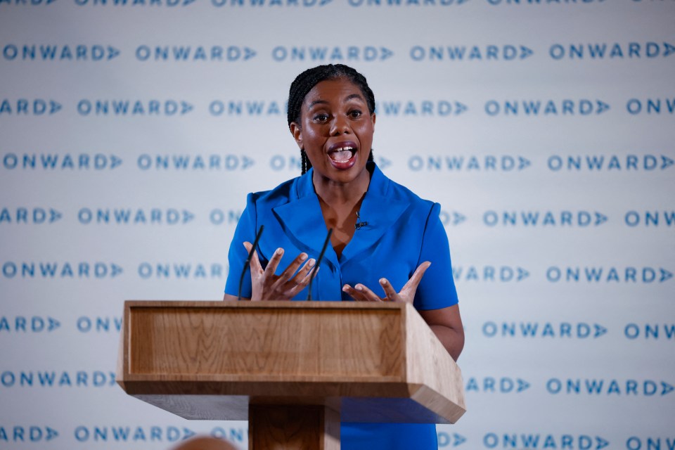 Kemi Badenoch giving a speech at a podium.