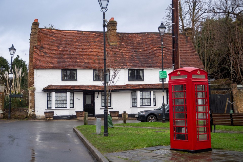 Harmondsworth village near London Heathrow, with a red telephone booth and a white house.