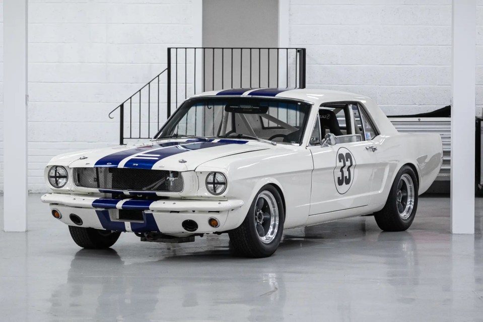 White 1966 Ford Mustang race car with blue stripes and number 33.