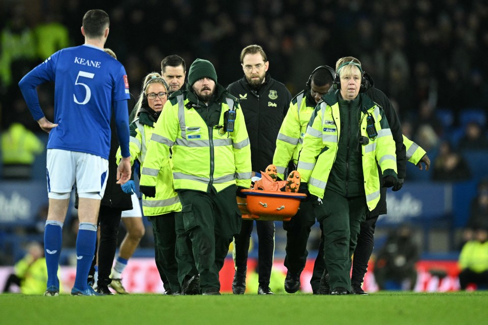 Medics carry an injured Armando Broja from a soccer field on a stretcher.